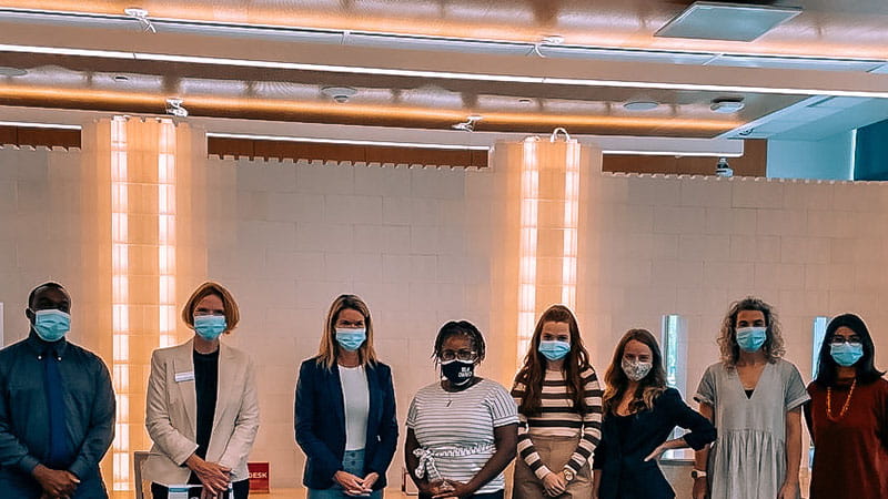 Group of people wearing masks standing in a line side-by-side
